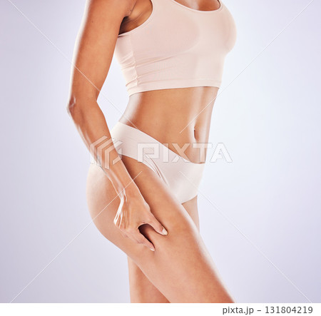 Health, liposuction and legs of woman in studio for weight loss, wellness and exercise on white background. Skincare, fitness and girl pinch leg in underwear for workout, diet routine and slim figure Health, liposuction and legs of woman in studio for weight loss, wellness and exercise on white background. Skincare, fitness and girl pinch leg in underwear for workout, diet routine and slim figure 131804219