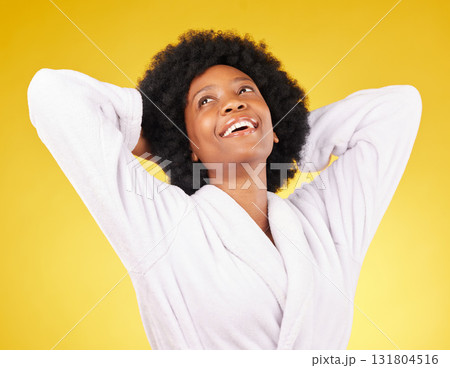 Black woman relax, bathrobe and happiness in a studio ready for luxury spa treatment for self care. Isolated, yellow background and happy young female with a smile from skincare and wellness 131804516