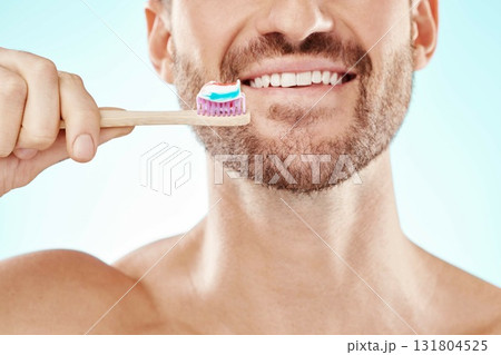 Smile, mouth or happy man brushing teeth with dental toothpaste for healthy oral hygiene grooming in studio. Eco friendly, zoom or male model cleaning with a smile or natural bamboo wood toothbrush Smile, mouth or happy man brushing teeth with dental toothpaste for healthy oral hygiene grooming in studio. Eco friendly, zoom or male model cleaning with a smile or natural bamboo wood toothbrush 131804525