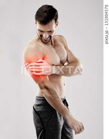 Sports, looking and a man with arm pain and muscle injury isolated on a grey studio background. Emergency, broken bone and person touching a painful, inflamed and hurt area in the body on a backdrop Sports, looking and a man with arm pain and muscle injury isolated on a grey studio background. Emergency, broken bone and person touching a painful, inflamed and hurt area in the body on a backdrop 131804578