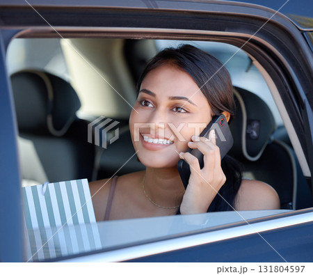 Phone call, shopping and ride share with a woman customer sitting in the backseat of a car for transport. Travel, retail and communication with an attractive young female shopper in a vehicle Phone call, shopping and ride share with a woman customer sitting in the backseat of a car for transport. Travel, retail and communication with an attractive young female shopper in a vehicle 131804597