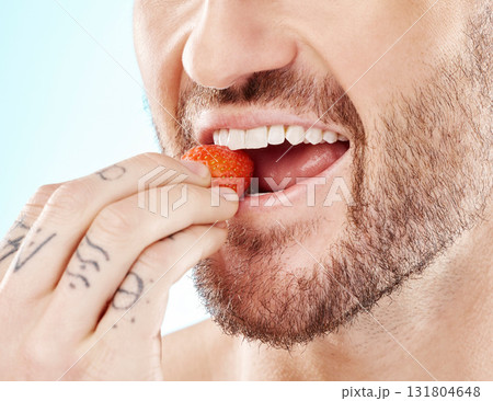 Health, eating and strawberry with mouth of man for diet, detox and nutrition product. Wellness, smile and teeth with model and biting fruit closeup for vitamin c, glow and fiber in blue background Health, eating and strawberry with mouth of man for diet, detox and nutrition product. Wellness, smile and teeth with model and biting fruit closeup for vitamin c, glow and fiber in blue background 131804648