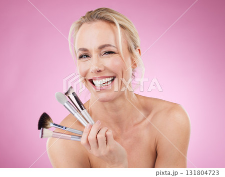 Portrait, makeup brush or laugh with a mature woman in studio on a pink background to promote a cosmetic product. Face, happy and cosmetics with an attractive older female posing for beauty treatment 131804723