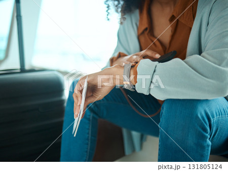 Black woman, travel and check time, airport and wait to board flight with watch, plan ticket and luggage. Ready for adventure, traveller and vacation with airplane transportation and holiday abroad Black woman, travel and check time, airport and wait to board flight with watch, plan ticket and luggage. Ready for adventure, traveller and vacation with airplane transportation and holiday abroad 131805124