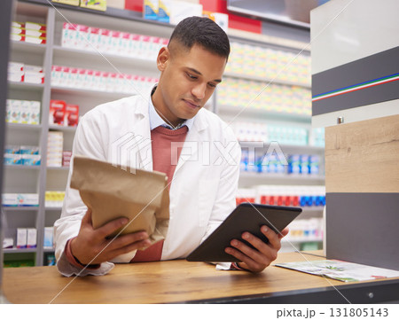 Pharmacy, tablet and pharmacist doing research on medication on the internet in a clinic. Healthcare, medical and male doctor or chemist reading information on prescription medicine on mobile device. 131805143