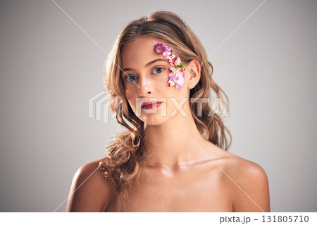 Beauty, flowers and portrait of woman in studio for natural cosmetics, skincare wellness and makeup products. Spring, art and girl with petal on face for spa aesthetic, luxury facial and cosmetology 131805710