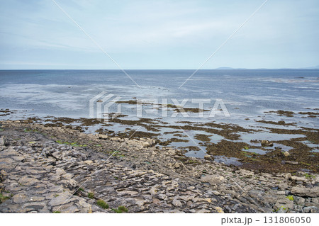 A beautiful view of the Irish coast, featuring the ocean, rocks, and a cloudy sky. A beautiful view of the Irish coast, featuring the ocean, rocks, and a cloudy sky. 131806050