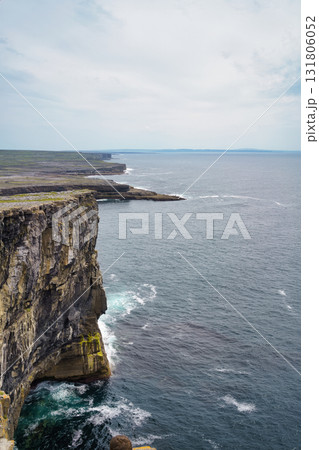 Scenic view of the Irish coastline, with rugged cliffs overlooking the vast Atlantic Ocean under a cloudy sky. 131806052