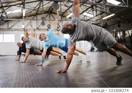 People, fitness and side plank in class with personal trainer for workout, stretching exercise or training. Diverse group in warm up stretch session with coach for cardio wellness or balance on floor People, fitness and side plank in class with personal trainer for workout, stretching exercise or training. Diverse group in warm up stretch session with coach for cardio wellness or balance on floor 131806274
