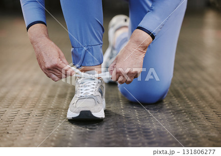 Sports, hands and tie shoes in gym to start workout, training or exercise for wellness. Fitness, athlete health or senior woman tying sneakers or footwear laces to get ready for exercising or running 131806277