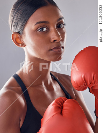 Boxer, gloves and portrait of woman in studio for sports exercise, strong muscle or mma training. Indian female, boxing workout and fist fight for impact, energy and warrior power in battle challenge Boxer, gloves and portrait of woman in studio for sports exercise, strong muscle or mma training. Indian female, boxing workout and fist fight for impact, energy and warrior power in battle challenge 131806352