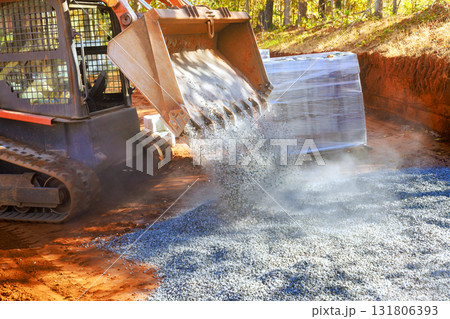Construction track loader unloads gravel at site active building progress in works day 131806393