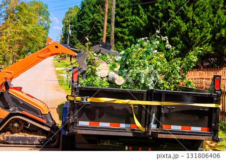 Crawler tractor loader collects branches debris from neighborhood road after hurricane Crawler tractor loader collects branches debris from neighborhood road after hurricane 131806406