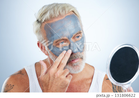 Man, mirror and clay mask for face skincare, wellness and organic cleaning with smile by studio background. Elderly male, hand and natural charcoal product for facial cosmetics for dermatology detox 131806622
