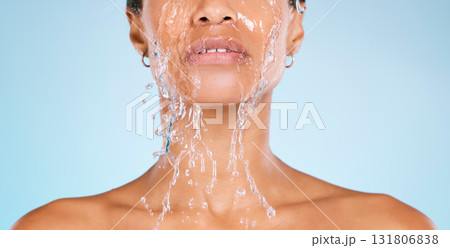 Face, water and cleaning with a black woman in studio on a blue background for hygiene or hydration. Splash, shower and bathroom with a young female washing her body for natural skincare or wellness Face, water and cleaning with a black woman in studio on a blue background for hygiene or hydration. Splash, shower and bathroom with a young female washing her body for natural skincare or wellness 131806838