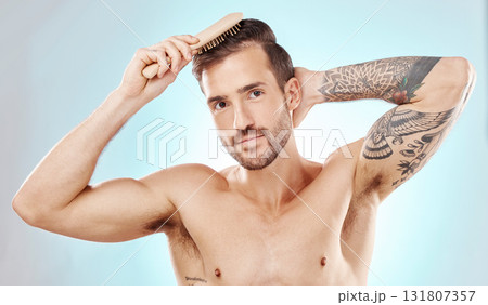 Hair care, man in portrait and beauty with brush and grooming with hygiene on blue background. Cosmetics, clean and fresh with hairstyle, wellness and routine with skin, glow and skincare 131807357