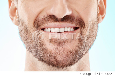 Teeth, smile and mouth of a man for dental care isolated on a blue background in a studio. Beard, happy and model showing results from whitening of tooth and promotion of an oral hygiene treatment 131807382