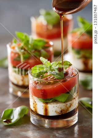 Delicious Layered Salad With Tomatoes, Basil, and Balsamic Dressing in Small Glass Cups 131807467