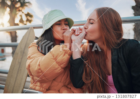 Playful, kiss and friends with a hand promise, support and secret in the city of California. Happy, together and women with affection, outdoor conversation and playing with happiness as besties 131807827