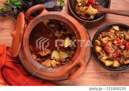 Chanakhi, a Georgian dish. in a clay pot, on a wooden table, stewed meat with vegetables, homemade, no people, 131808220