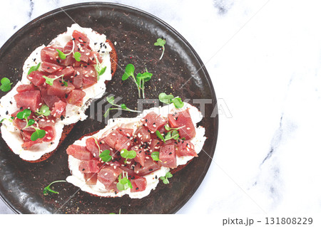 sandwiches, rye bread with cream cheese, sliced tuna fillet with herbs, breakfast on a black plate, homemade, sandwiches, rye bread with cream cheese, sliced tuna fillet with herbs, breakfast on a black plate, homemade, 131808229