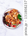 Baked quail, served on a plate with crispy lettuce leaves, fresh tomatoes and herbs, on a white plate, homemade, 131808237