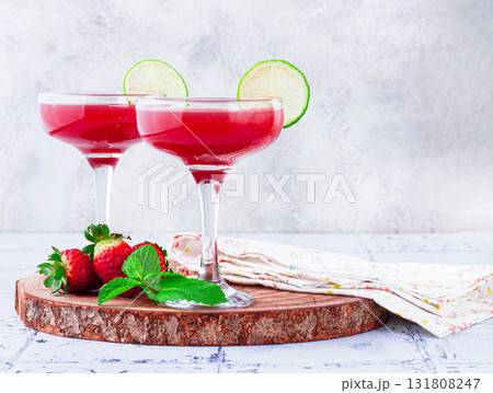 Refreshing cocktail in an elegant glass with lime and strawberries, sunshine, no people, 131808247