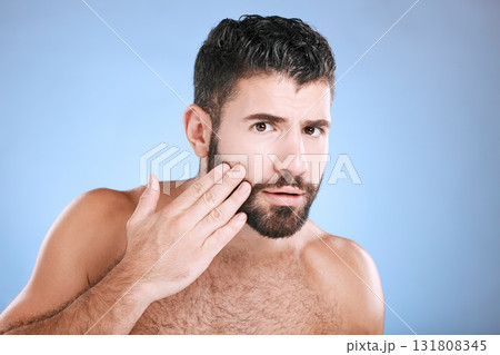 Skincare, beard grooming and portrait of man on blue background for beauty, wellness and salon. Luxury spa, dermatology and worried male check face for healthy skin, blackhead and facial hair growth 131808345