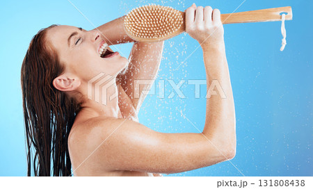 Shower karaoke, skincare and woman with happiness singing in a studio. Bathroom, music and happy female model with isolated blue background and cleaning brush for beauty routine and wellness Shower karaoke, skincare and woman with happiness singing in a studio. Bathroom, music and happy female model with isolated blue background and cleaning brush for beauty routine and wellness 131808438