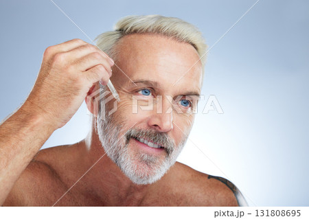 Old man, smile and facial oil for skincare, beauty and grooming, apply serum on face against studio background. Dropper, anti aging cosmetic care with senior male and mockup, hygiene with dermatology 131808695