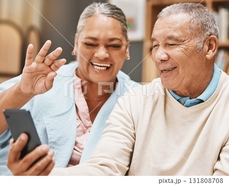Video call, wave or happy old couple talking, communication or speaking in conversation in retirement. Partnership, elderly man or senior woman greeting online on phone at home together with smile Video call, wave or happy old couple talking, communication or speaking in conversation in retirement. Partnership, elderly man or senior woman greeting online on phone at home together with smile 131808708