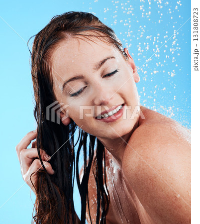 Shower hair care, water and woman in a studio feeling happy from cleaning and skincare. Wellness, splash and beauty routine of a female model with dermatology and shampoo wash with blue background Shower hair care, water and woman in a studio feeling happy from cleaning and skincare. Wellness, splash and beauty routine of a female model with dermatology and shampoo wash with blue background 131808723