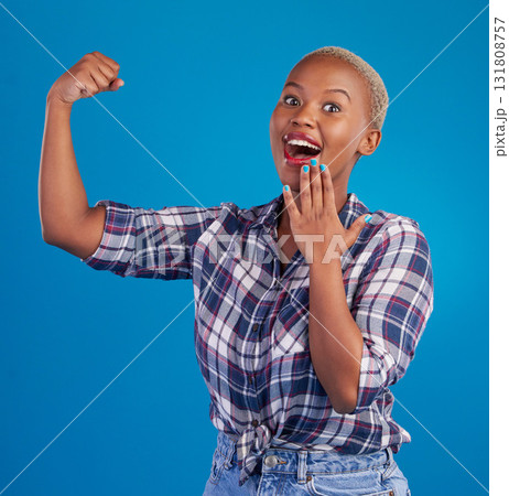 Shocked, arm flex and portrait of black woman in studio for empowerment, confident or success. Achievement, hard work and pride with female isolated on blue background for power, strong or motivation 131808757