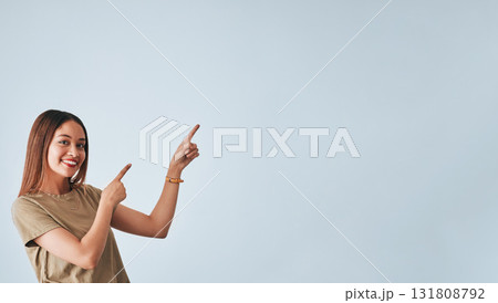 Woman, smile and pointing hand at space for idea in studio advertising product placement mockup. Happy female on white background show logo or branding with discount, promotion or sale announcement 131808792