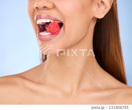 Mouth, beauty and strawberry with a model woman in studio on a blue background closeup biting a fruit. Food, health and nutrition with a female eating a berry for antioxidants or diet benefits Mouth, beauty and strawberry with a model woman in studio on a blue background closeup biting a fruit. Food, health and nutrition with a female eating a berry for antioxidants or diet benefits 131808795