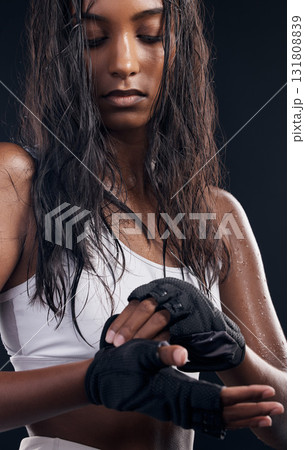 Boxer, gloves and sweat with a sports woman getting ready in studio on a black background for fitness. Exercise, health and training with a female boxing athlete sweating during a combat workout Boxer, gloves and sweat with a sports woman getting ready in studio on a black background for fitness. Exercise, health and training with a female boxing athlete sweating during a combat workout 131808839