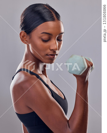 Woman, bicep and dumbbell training in studio for strong body, action and wellness goals. Indian female, bodybuilder and weights of fitness, power exercise and muscle energy for healthy sports workout Woman, bicep and dumbbell training in studio for strong body, action and wellness goals. Indian female, bodybuilder and weights of fitness, power exercise and muscle energy for healthy sports workout 131808866