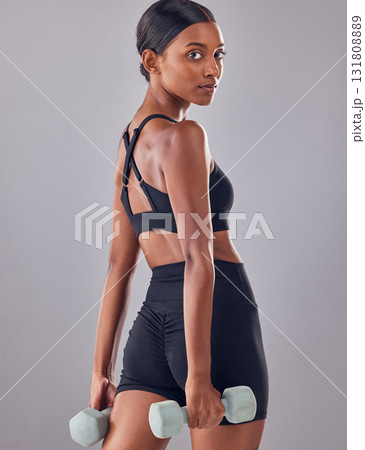Woman, portrait and dumbbell exercise in studio for strong body, wellness and healthy lifestyle goals. Indian female, bodybuilder and weights for fitness, training and muscle energy in sports workout Woman, portrait and dumbbell exercise in studio for strong body, wellness and healthy lifestyle goals. Indian female, bodybuilder and weights for fitness, training and muscle energy in sports workout 131808889