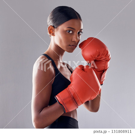 Boxing, gloves and portrait of woman in studio for sports exercise, strong muscle or mma training. Indian female boxer, workout and fist fight for impact, energy and warrior power in battle challenge Boxing, gloves and portrait of woman in studio for sports exercise, strong muscle or mma training. Indian female boxer, workout and fist fight for impact, energy and warrior power in battle challenge 131808911