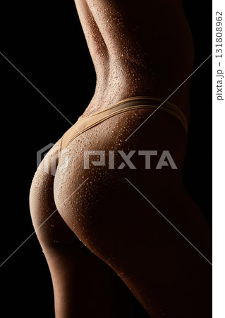 Close-up of an wet female back with water drops on a black background Close-up of an wet female back with water drops on a black background 131808962