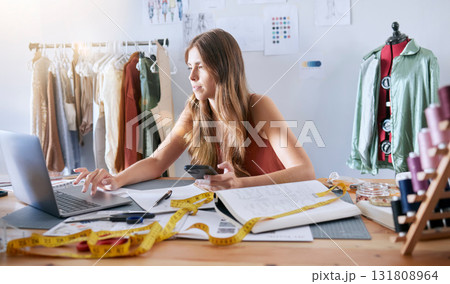 Laptop, fashion and woman designer working on an online design with technology in a workshop. Creative, tech and female small business owner planning a clothing collection on a computer in her studio 131808964