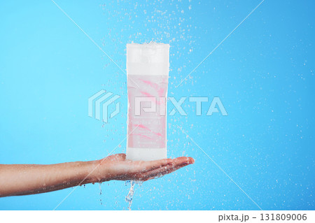 Shampoo, showing and hand with a bottle in the shower isolated on a blue background in studio. Cleaning, hygiene and person advertising a product for grooming, sanitary care and treatment with mockup Shampoo, showing and hand with a bottle in the shower isolated on a blue background in studio. Cleaning, hygiene and person advertising a product for grooming, sanitary care and treatment with mockup 131809006