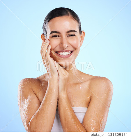 Happy woman, shower and portrait smile for skincare hygiene, dermatology or wellness against a blue studio background. Calm female face in natural beauty cosmetics, water drops or facial treatment 131809184