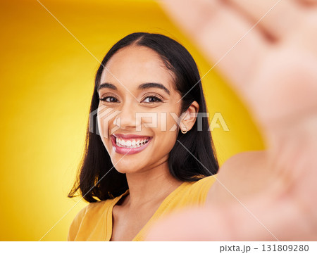 Happy, smile and selfie with woman in studio for social media, confidence and picture. Photo, happiness and relax with portrait of female on yellow background for beauty, self care and influencer Happy, smile and selfie with woman in studio for social media, confidence and picture. Photo, happiness and relax with portrait of female on yellow background for beauty, self care and influencer 131809280