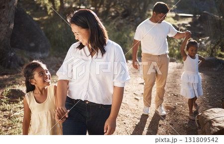 Family, happy and walking in the park for bonding, fun and care in summer outside. Mother, father and parents playfully walk with girl children, kids and siblings in nature garden for summer bonding 131809542