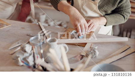Creative artist, hands and pottery manufacturing closeup in studio, workshop craft and small business for production process. Clay, ceramic designer and artisan mold mud sculpture in class at table. 131810116