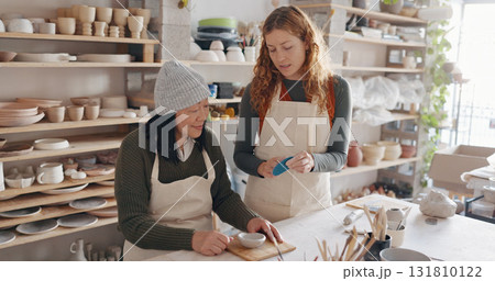 Pottery, art and teacher with student in a workshop for learning with clay sculpting or molding. Creative, teaching and artist manufacturing a mud ceramic design product with mentor in a studio. Pottery, art and teacher with student in a workshop for learning with clay sculpting or molding. Creative, teaching and artist manufacturing a mud ceramic design product with mentor in a studio. 131810122