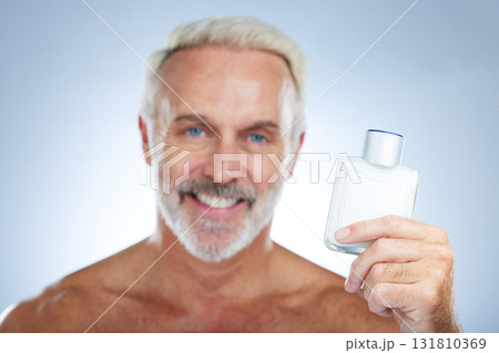 Old man, cologne aftershave and portrait in a studio with perfume and spray bottle product with a smile. Isolated, grey background and happiness of a senior and elderly model with beauty routine 131810369