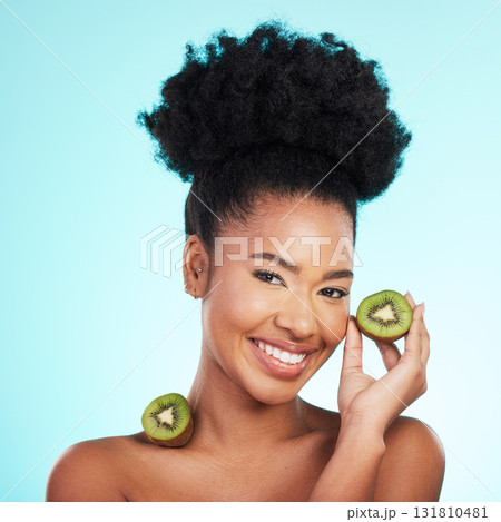 Kiwi fruit, skincare and woman portrait of beauty, wellness and detox healthcare. Isolated, blue background and studio with a young female feeling happy from healthy food with vitamin c for glow Kiwi fruit, skincare and woman portrait of beauty, wellness and detox healthcare. Isolated, blue background and studio with a young female feeling happy from healthy food with vitamin c for glow 131810481