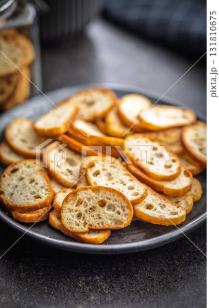 Crispy roasted bruschetta bread on plate on black table. 131810675